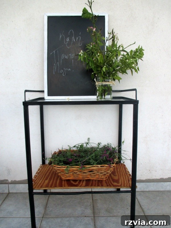 After: The fully restored metal table with a black painted frame, a rustic plywood bottom shelf, and a clear glass top, showcasing its farmhouse chic transformation.