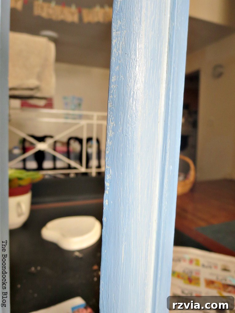 Painting the wooden book shelf with blue paint.