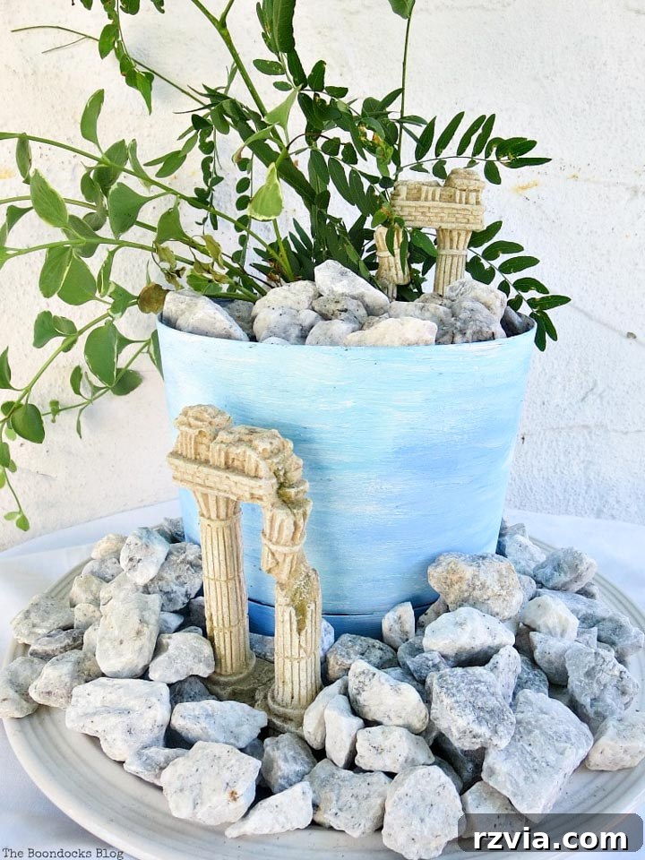 Seaside Style from Salvaged Treasures 2 A beautifully crafted DIY beach vignette featuring a blue planter, lush vinca vine, and natural pebbles, evoking a Mediterranean feel.
