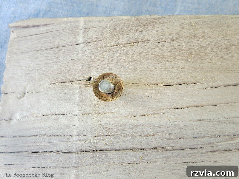 Coastal Creations from Repurposed Finds 12 Close-up of two drilled holes in the whitewashed plywood, prepared for attaching decorative knobs