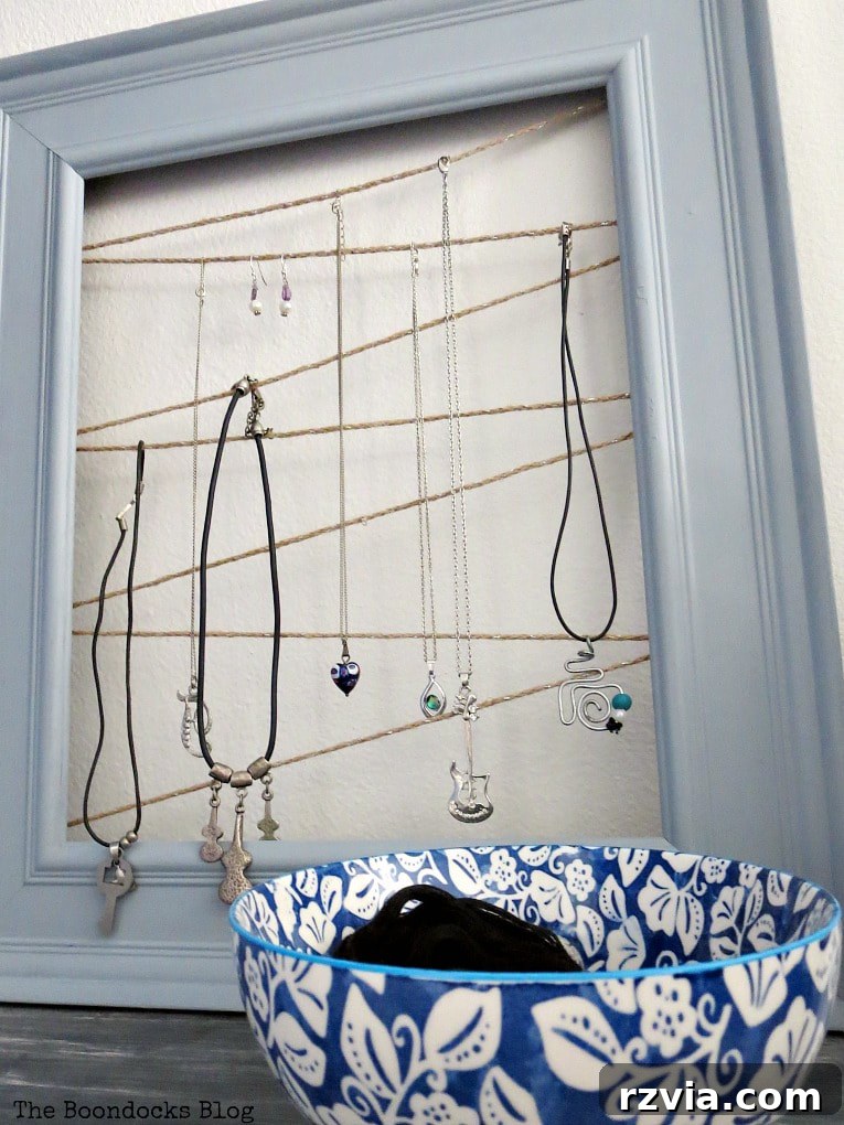 Final image of the DIY frame jewelry organizer, full of accessories, showcasing its practicality and charm. An ideal handmade Mother's Day gift or personal organization solution.