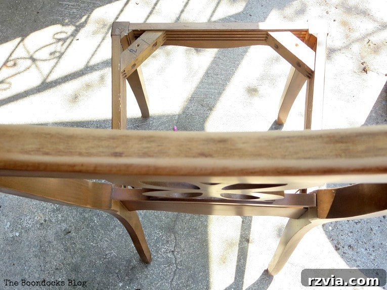 Sanding the chair frame to remove old stain drips and prepare for painting, a crucial step in furniture restoration.