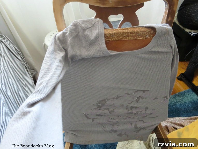Attempting to use a t-shirt as a quick chair seat cover, demonstrating a creative and budget-friendly approach to upholstery.