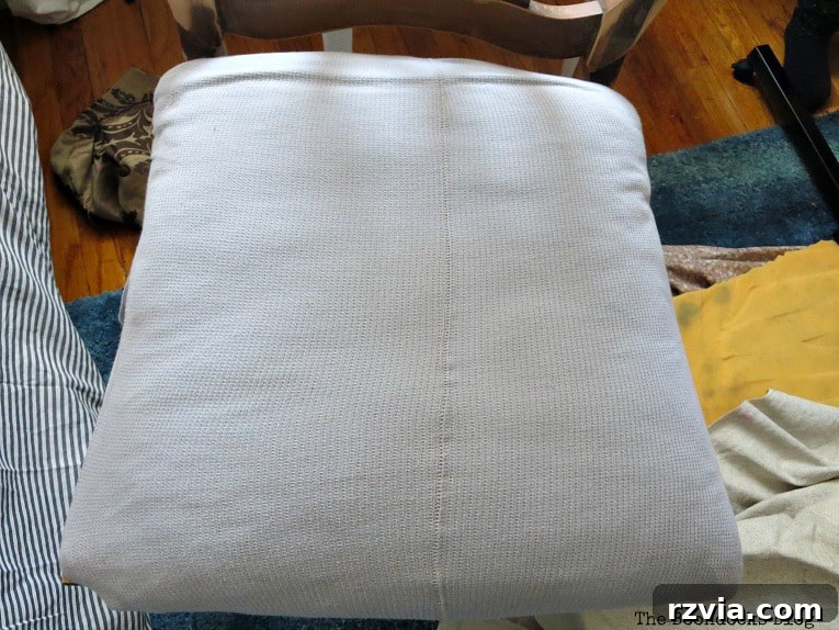 A close-up of the t-shirt used as a temporary chair seat cover, showing the seam that prompted a change in upholstery choice.
