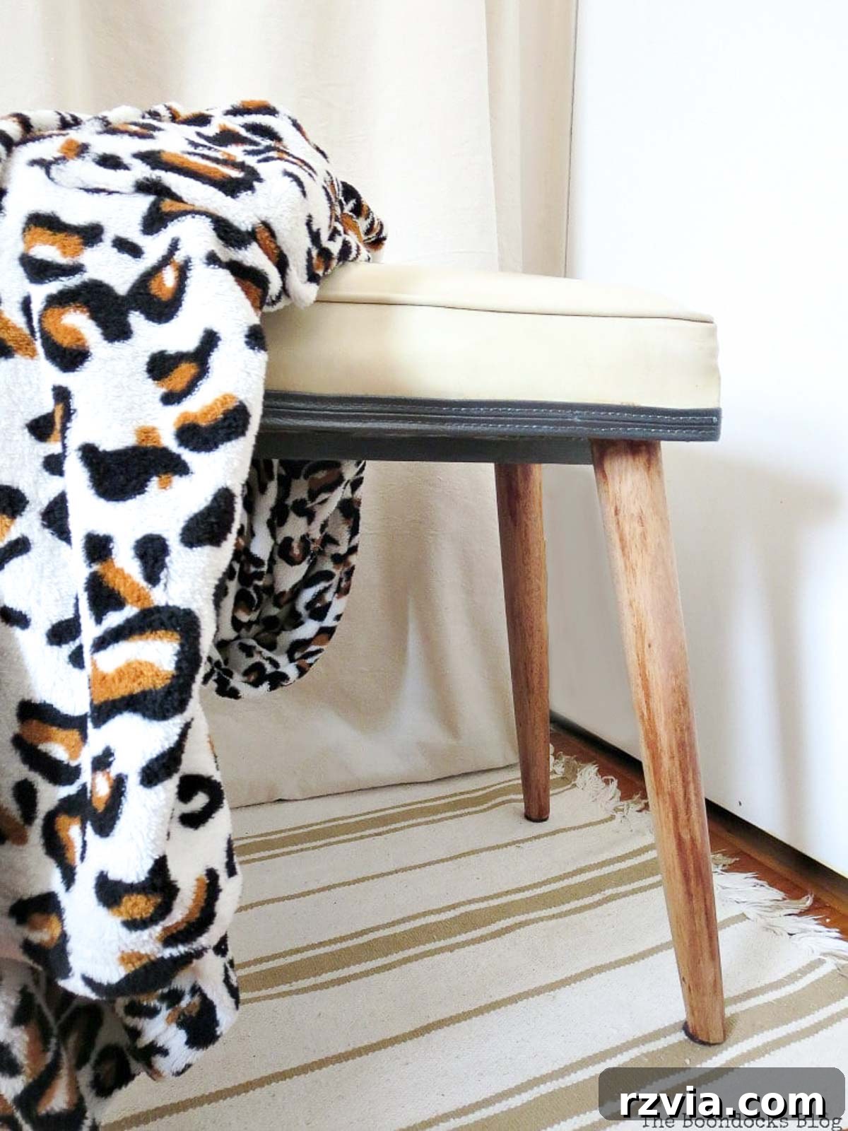 Side view of the revitalized Mid-Century Modern stool, showing its unique silhouette and natural wood finish.