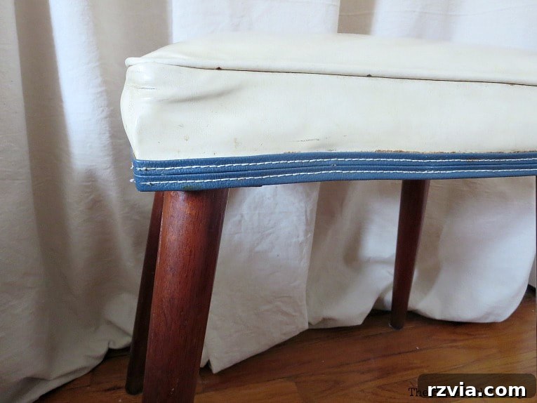Close-up of the Mid-Century Modern bench with visible details before renovation, showing faded blue piping.