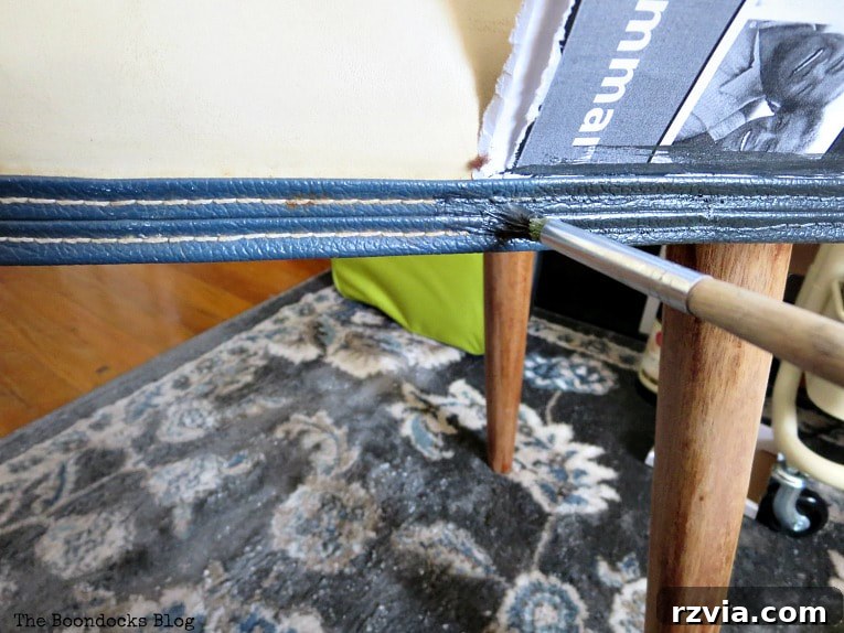 Painting the blue vinyl piping of the Mid-Century Modern bench with metallic acrylic paint for a contemporary look.