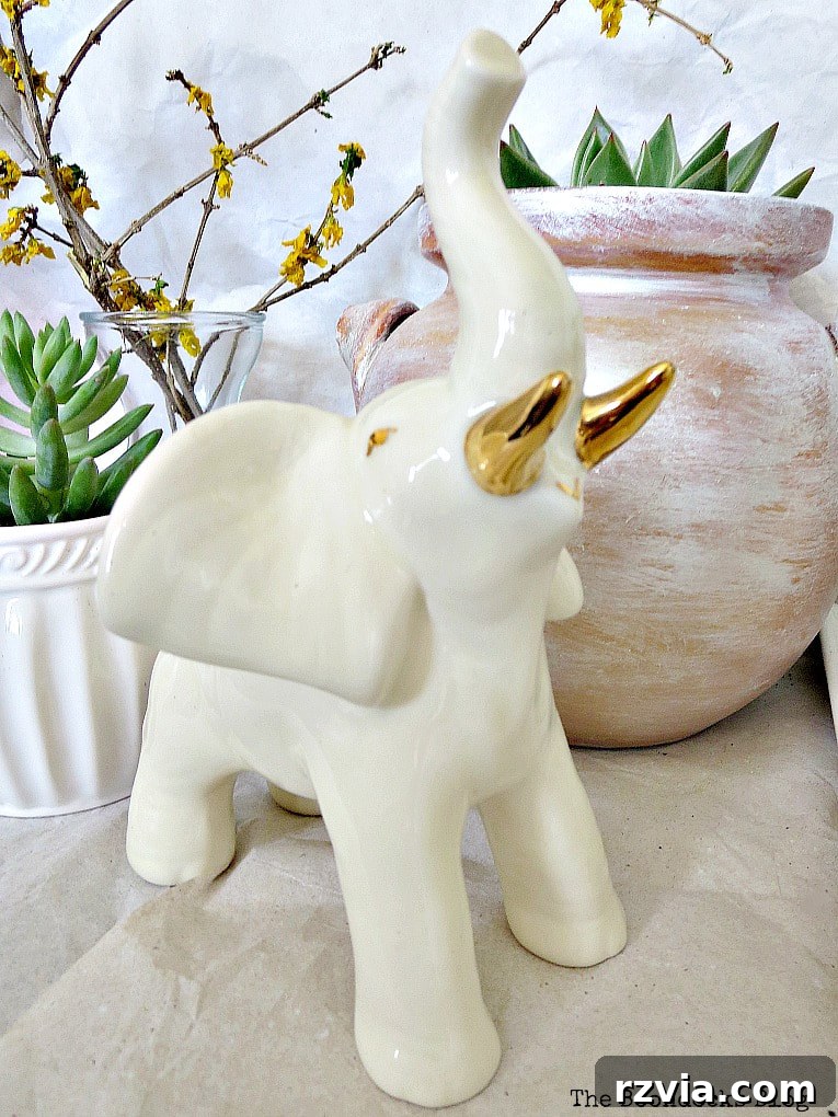 Beyond the Bin: DIY Upcycled Planters 13 A majestic ceramic ivory elephant with intricate details and golden tusks, serving as a unique decorative accent within the vignette.