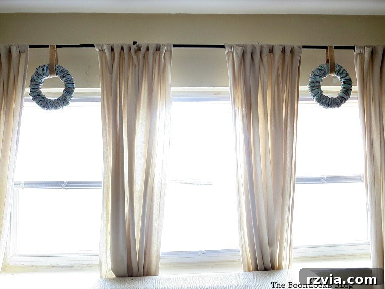 Bright Ideas Easy Colorful Packing Paper Wreath 13 Two easy DIY wreaths made from colorful packing paper, beautifully displayed on a living room curtain rod, creating a harmonious and personalized decorative arrangement.