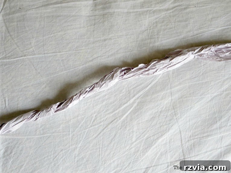 Bright Ideas Easy Colorful Packing Paper Wreath 5 A close-up shot of a long strip of packing paper being twisted into a rope-like form, demonstrating the technique for adding texture to the DIY wreath.
