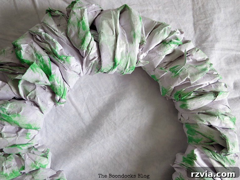 Bright Ideas Easy Colorful Packing Paper Wreath 8 A DIY paper wreath base being painted with a vibrant green acrylic paint, showcasing the personalization stage of the crafting process.