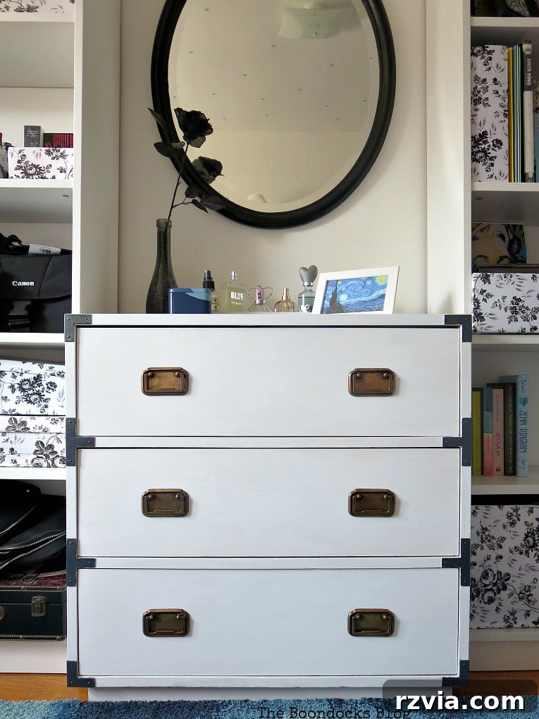Bringing a Campaign Dresser Back to Life 2 Restored white campaign dresser flanked by two bookcases with a black mirror hanging above it, showcasing its elegant transformation.