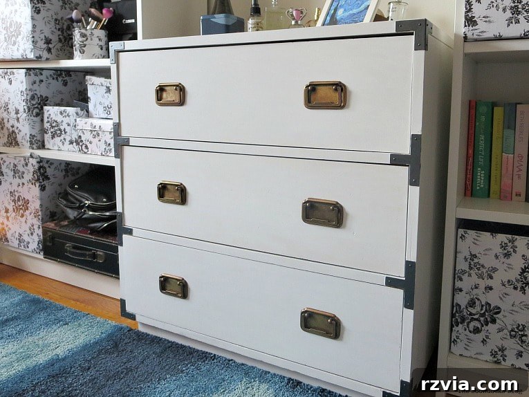 Bringing a Campaign Dresser Back to Life 14 The finished white dresser with updated hardware, situated elegantly between two bookcases in the completed bedroom setting.