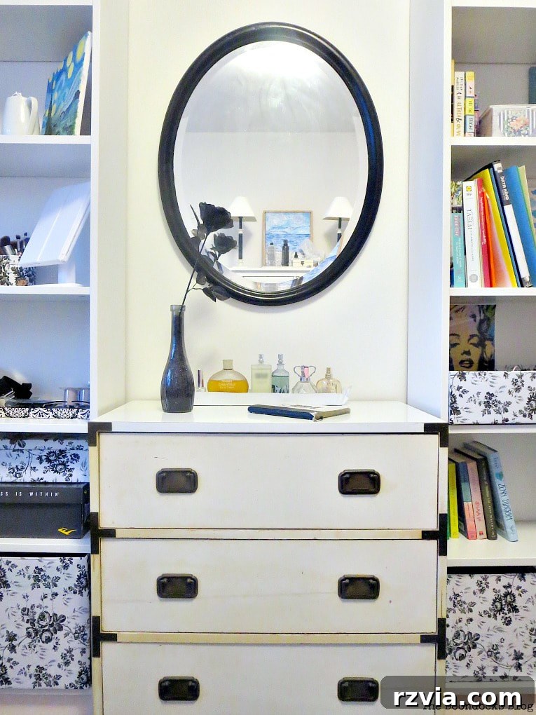 Bringing a Campaign Dresser Back to Life 3 Before shot of the yellowing campaign dresser, positioned between two bookcases with a black mirror above, highlighting its aged appearance.