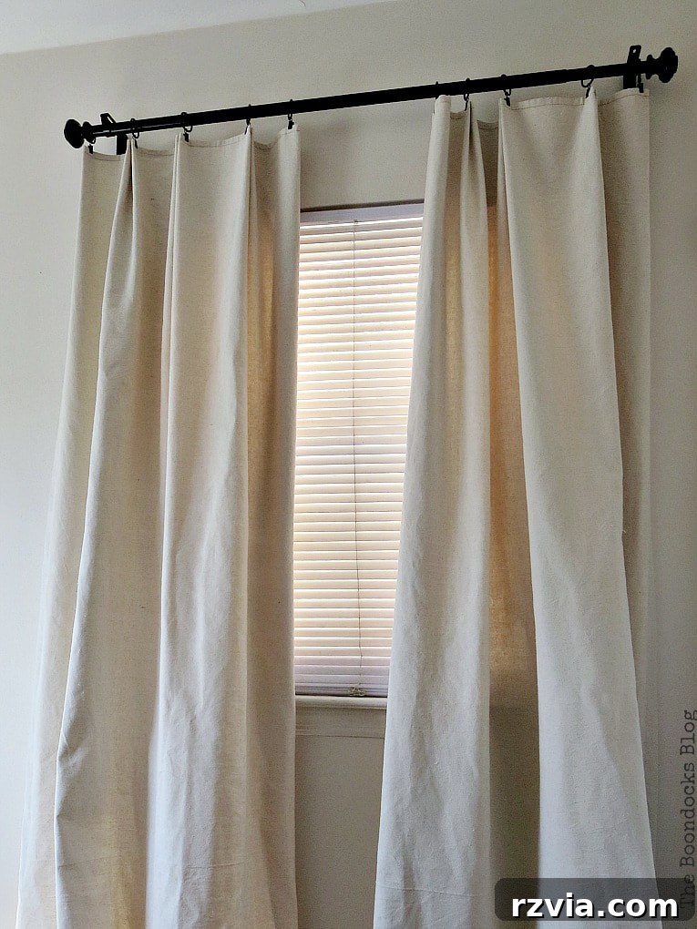 Crafting Elegant Pleated Curtains from Humble Drop Cloths 17 A small window appearing larger due to the high and wide placement of drop cloth curtains, showing a smart styling trick.