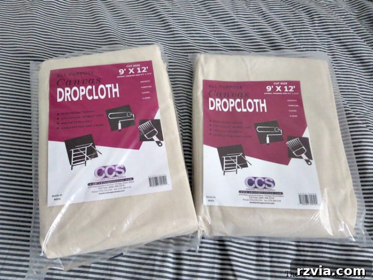 Crafting Elegant Pleated Curtains from Humble Drop Cloths 4 Roll of canvas drop cloth fabric unfolded on a table, ready for crafting.