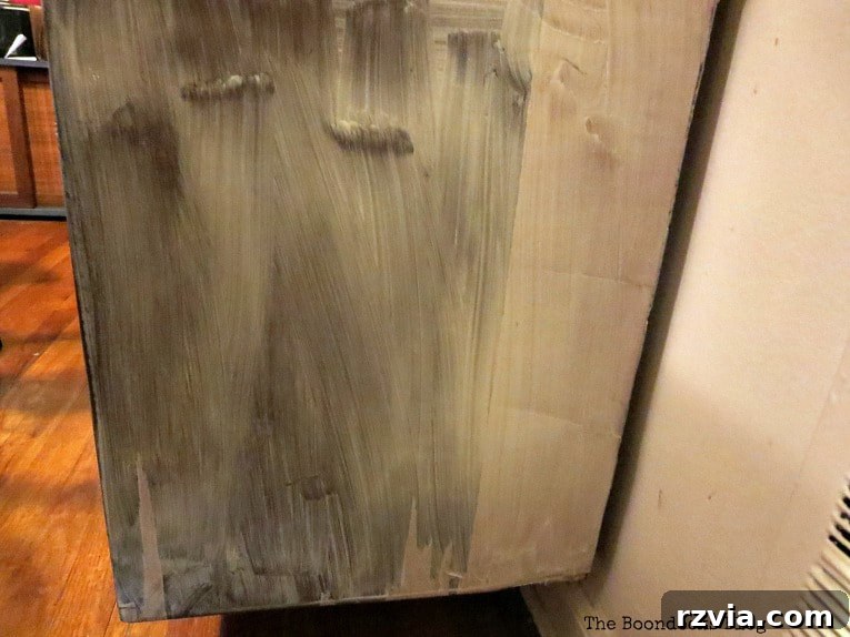 Revitalize Your MCM China Cabinet 11 Methodically applying wood reclaim to the side of the cabinet to repair and smooth the surface damaged by peeling veneer.