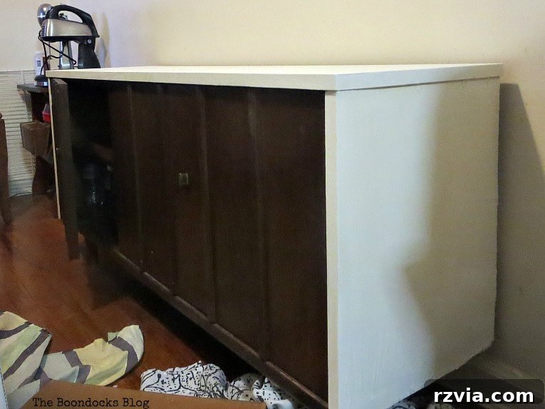 Revitalize Your MCM China Cabinet 12 The bottom half of the china cabinet, expertly painted with white chalk finish paint, blending seamlessly with the unpainted wood elements.