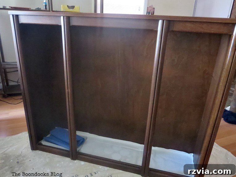 Revitalize Your MCM China Cabinet 4 Applying pure Tung oil to the smooth wooden surface of the top section of the china cabinet to enhance its natural luster.