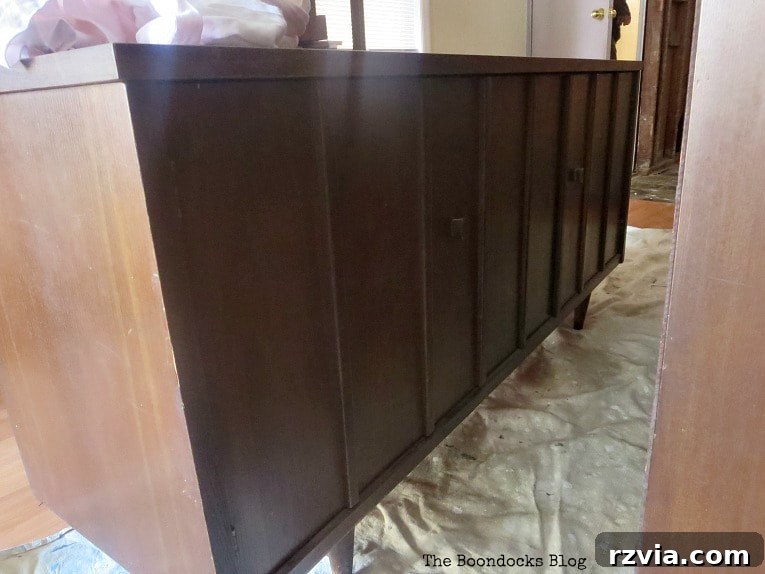 Revitalize Your MCM China Cabinet 5 Carefully applying Tung oil to the bottom section of the mid-century china cabinet to restore and protect the wood.
