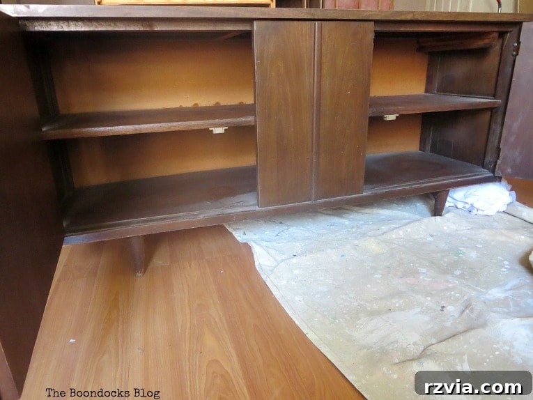 Revitalize Your MCM China Cabinet 7 Interior view of the bottom part of the china cabinet with doors open, showing storage space and the original construction.