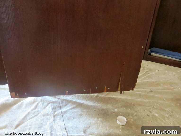 Revitalize Your MCM China Cabinet 8 Detail of the damaged veneer on the side of the bottom cabinet, showing significant peeling and wear.
