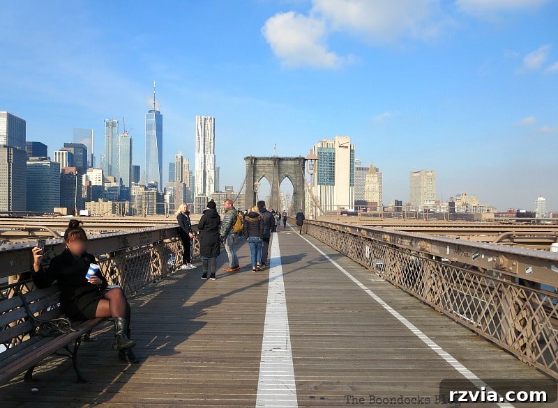 View from the center of the Brooklyn Bridge, showcasing the expanse and intricate details of the iconic structure. A Tour of the Astonishing Brooklyn Bridge Walkway.