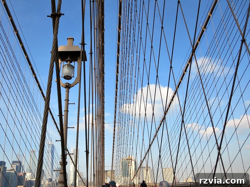 The intricate, web-like construction of the Brooklyn Bridge's massive steel cables, an engineering marvel. A Tour of the Astonishing Brooklyn Bridge Walkway.