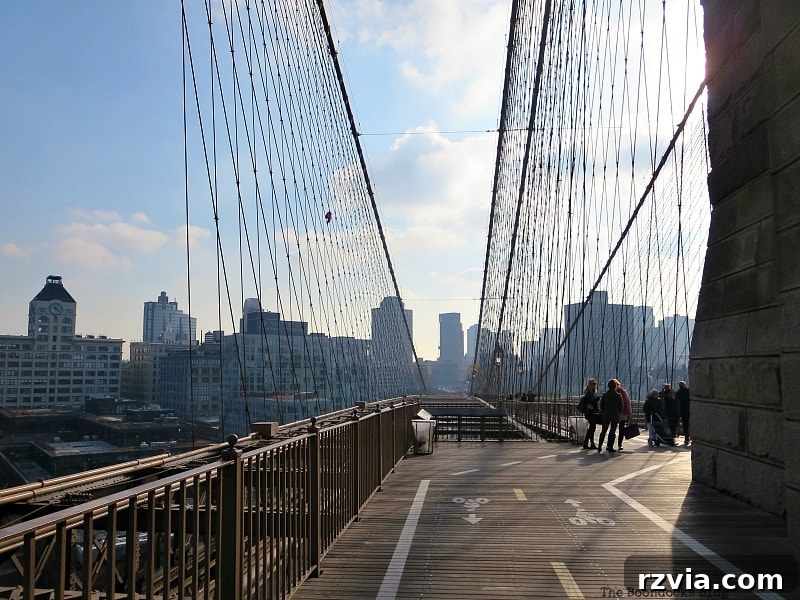 The spacious walkway of the Brooklyn Bridge gracefully snakes around the monumental towers, offering ample room for visitors. A Tour of the Astonishing Brooklyn Bridge Walkway.