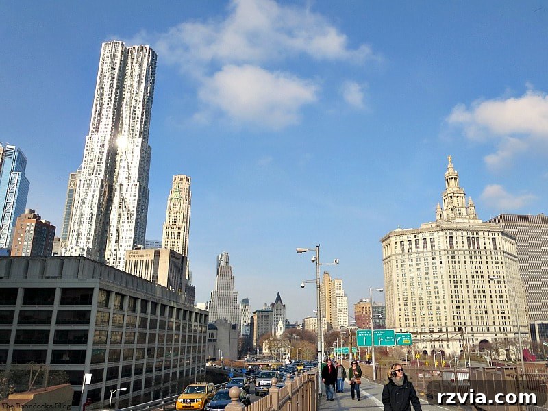 The bustling Manhattan entrance to the Brooklyn Bridge, with the Civic Center and 'New York by Gehry' in the background. A Tour of the Astonishing Brooklyn Bridge Walkway.