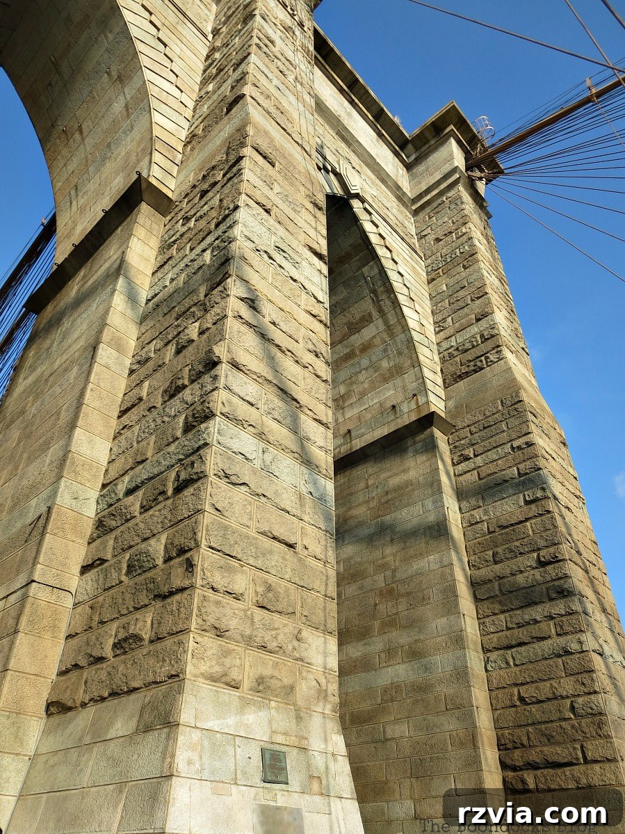 The massive and imposing towers of the Brooklyn Bridge, showcasing the intricate details of their Neo-Gothic architectural style. A Tour of the Astonishing Brooklyn Bridge Walkway.