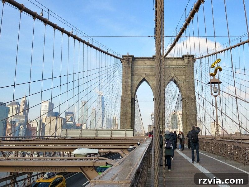 Tourists and photographers capturing the awe-inspiring Brooklyn Bridge towers from the walkway on the Brooklyn side. A Tour of the Astonishing Brooklyn Bridge Walkway.