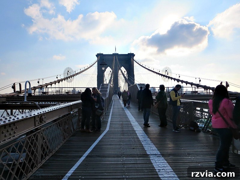The historic walkway of the Brooklyn Bridge, showcasing its unique design and inviting pedestrians. A Tour of the Astonishing Brooklyn Bridge Walkway.