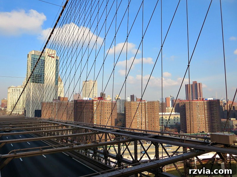 Northern view of Manhattan from the Brooklyn Bridge, showcasing a group of buildings and the distinctive Verizon tower. A Tour of the Astonishing Brooklyn Bridge Walkway.