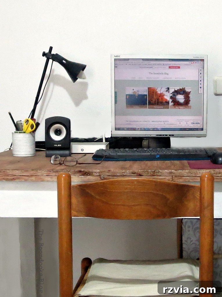 A close-up photograph of a simple wooden desk and chair, highlighting the clean lines and functional design suitable for a compact living space.