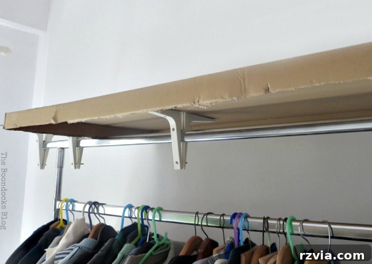 The clothes rack with IKEA brackets installed, and a custom-cut cardboard frame laid securely on top, ready for the next phase of the cover creation.