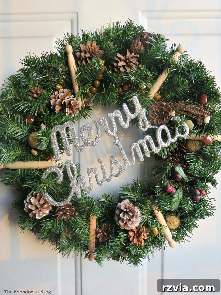 Kolay Rustik Noel Çelengi Yapımı ve 12 Ek Çelenk Fikri 12 The modified rustic Christmas wreath featuring a 'Merry Christmas' sign in place of the bells, allowing the door to close properly.