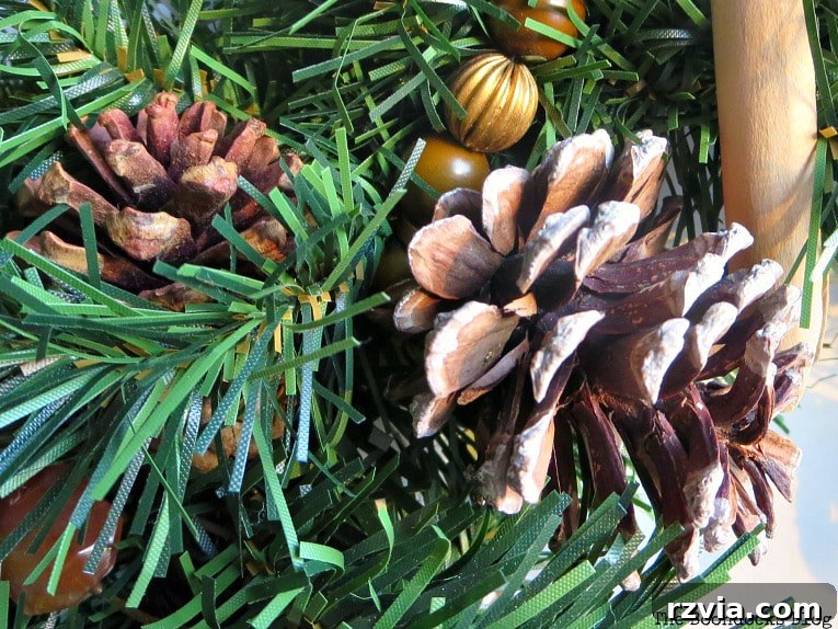 Kolay Rustik Noel Çelengi Yapımı ve 12 Ek Çelenk Fikri 3 Close-up of pine cones being glued onto a faux wreath frame, showcasing the initial step of the rustic Christmas wreath DIY.