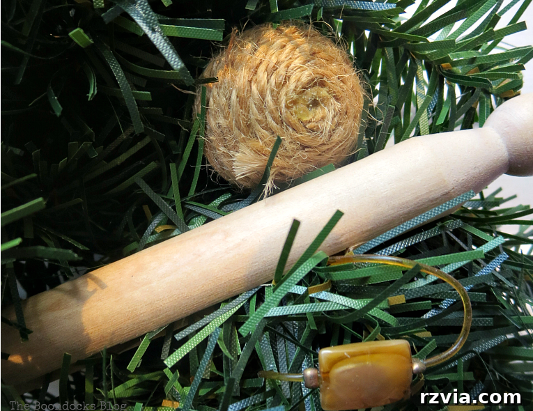 Kolay Rustik Noel Çelengi Yapımı ve 12 Ek Çelenk Fikri 5 Rustic Christmas wreath adorned with pine cones, vintage wooden clothespins, and twine-wrapped balls, showing the creative arrangement.