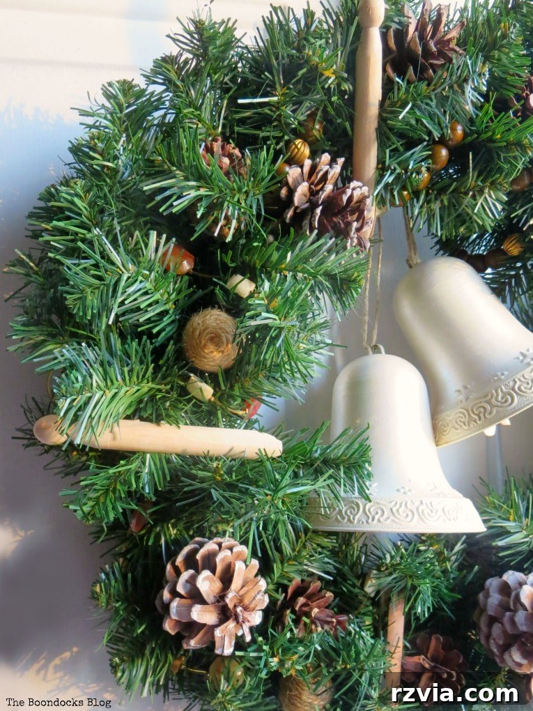 Kolay Rustik Noel Çelengi Yapımı ve 12 Ek Çelenk Fikri 10 A stunning rustic Christmas wreath hanging on a green front door, bathed in morning light, showcasing its handmade beauty.