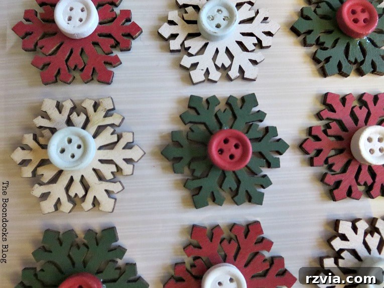 Close-up of small gift tag embellishments featuring snowflakes and buttons, ready for crafting into rustic Christmas ornaments.