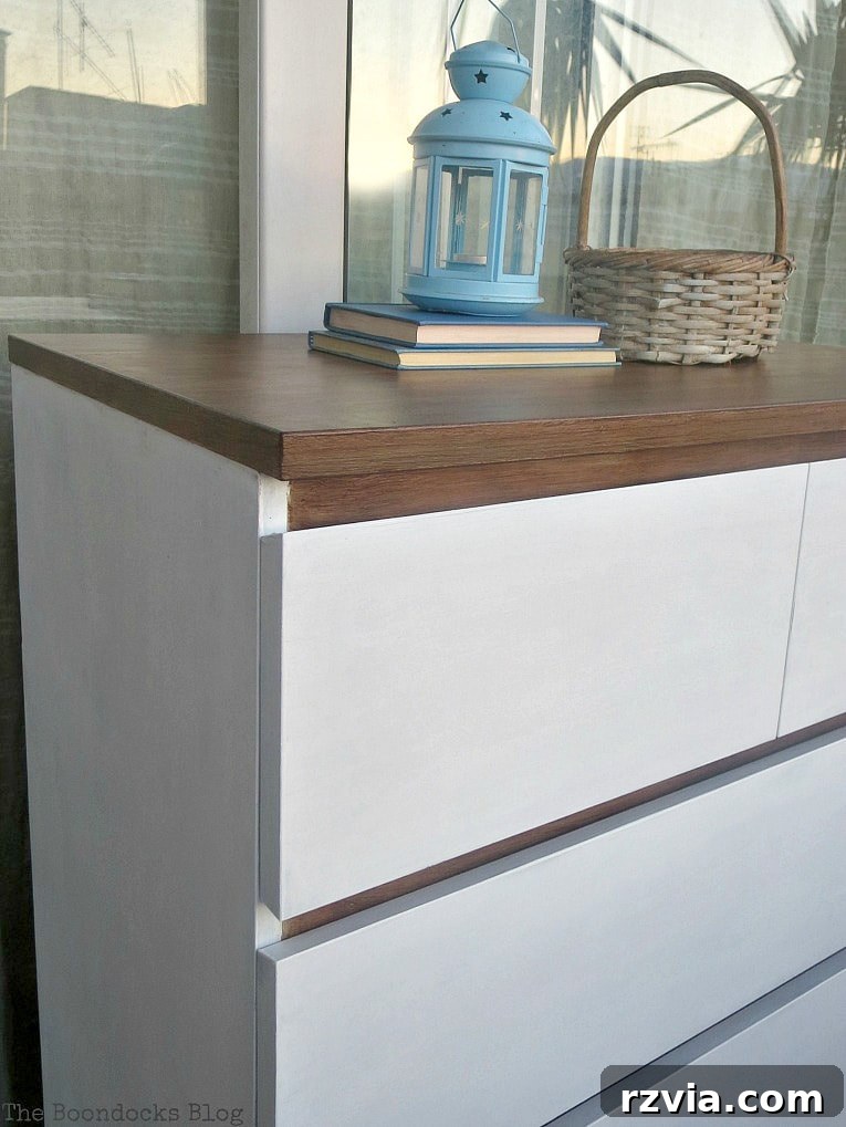Stunning Black Ikea Malm Dresser Makeovers 23 A close-up of decorative items, including a woven basket, a blue lantern, and two books, adorning the top of the finished dresser.
