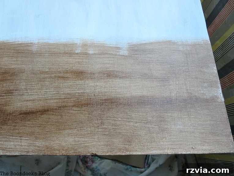 Applying gel stain to the table leaf with a round brush, creating texture.