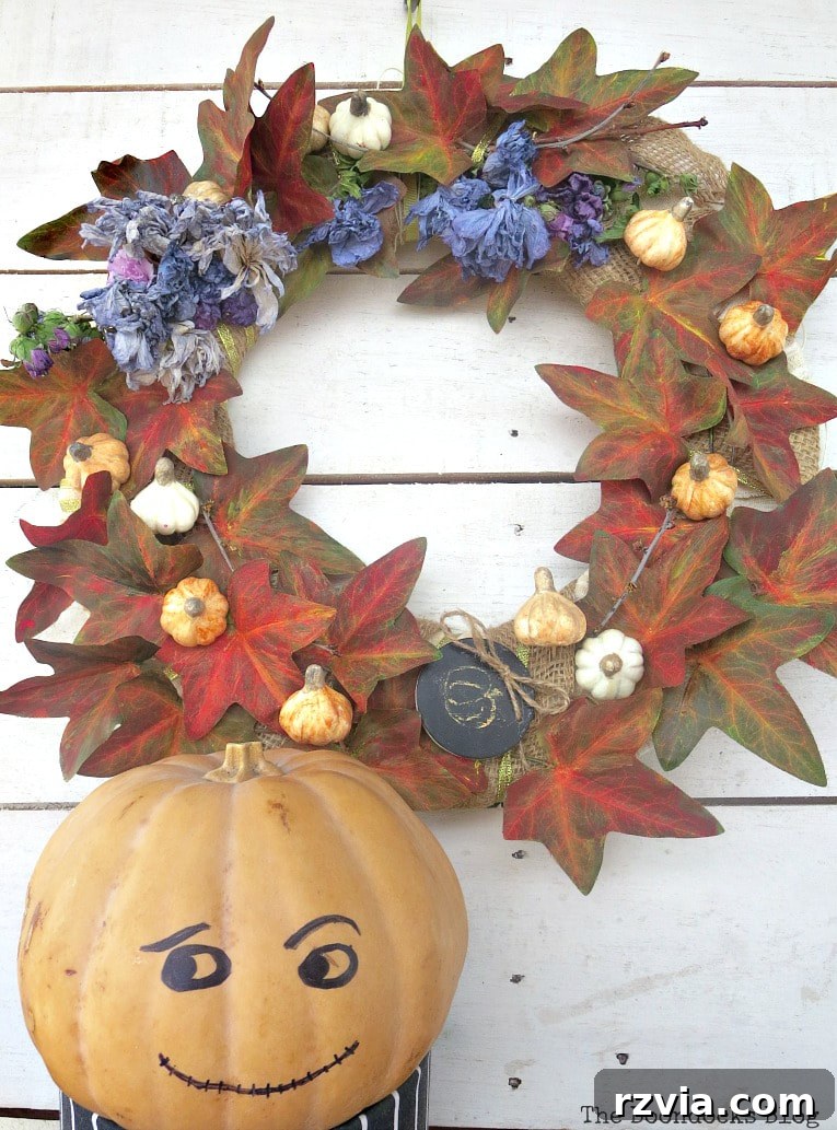 Dollar Store Vine Transformed into a Gorgeous Fall Wreath 24 The pumpkin man stands next to the finished DIY fall wreath, completing a charming autumn vignette.