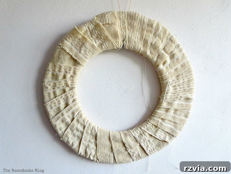 Dollar Store Vine Transformed into a Gorgeous Fall Wreath 7 Donut-shaped cardboard base wrapped in white fabric strips, providing a soft foundation for the dollar store fall wreath.