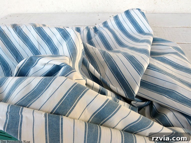Fabric Fix: Giving New Life to Old Plastic Baskets 4 A rectangular piece of blue and white striped fabric, carefully folded and ready for the upcycling project.
