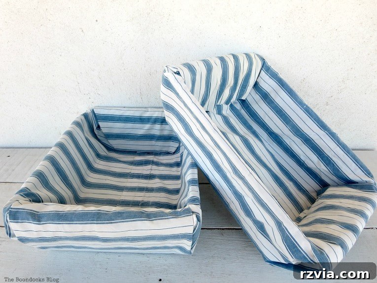 Fabric Fix: Giving New Life to Old Plastic Baskets 10 Two newly upcycled plastic baskets, now beautifully covered in blue and white striped fabric, ready for use.