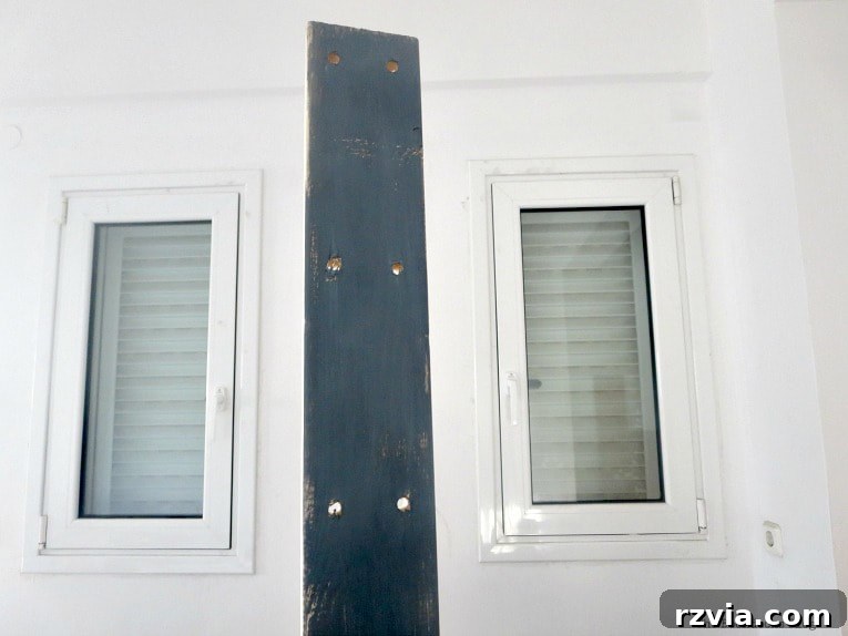 Elevate Your IKEA Hejne Shelf With A Fresh Coat Of Paint 5 Painting a wooden panel with grey paint.