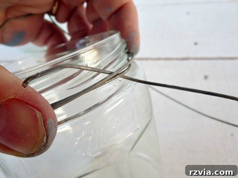 Transform Jars into Glowing Lanterns 12 The final step of securing the wire handle on the opposite side of the jar rim, completing the sturdy frame for a DIY hanging lantern.