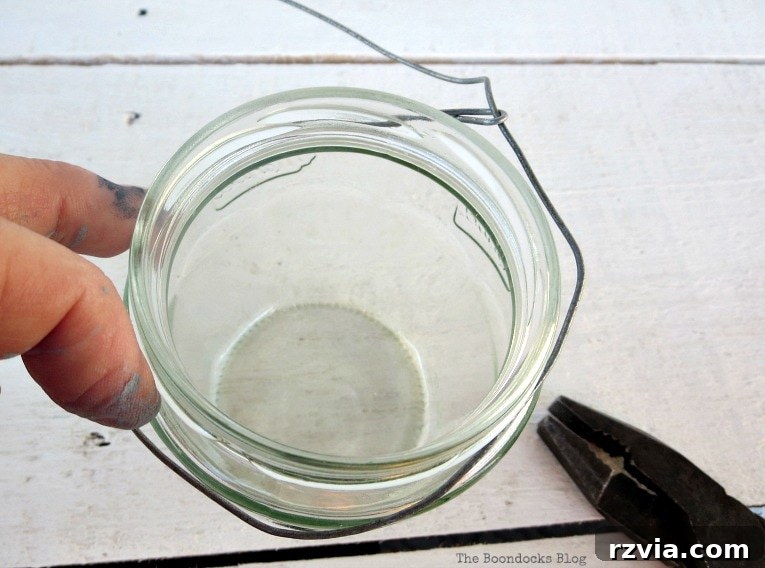 Transform Jars into Glowing Lanterns 8 A securely fitted circular wire frame positioned around the outer rim of a glass jar, demonstrating the base for a DIY hanging lantern.